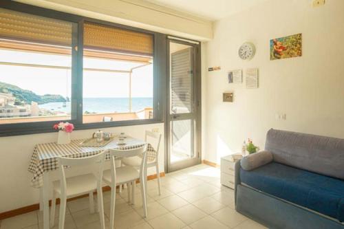 a living room with a table and a blue couch at Giglio Rosa 4 n23 in Campese