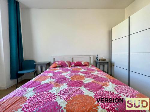 1 dormitorio con 1 cama con un edredón colorido en Version Sud- Appartement moderne proche gare, en Toulon