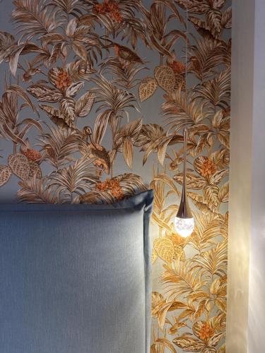 a wall with a wallpaper with a chair in a room at Tiny House Bos in Moergestel