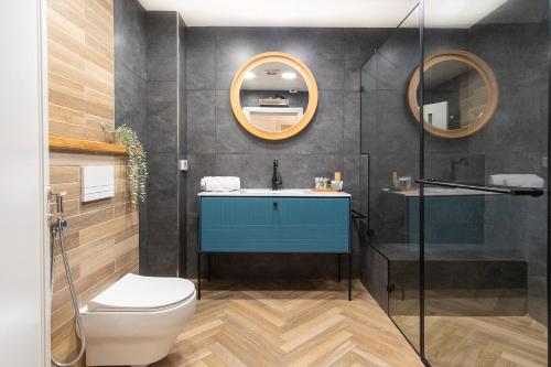 een badkamer met een wastafel, een toilet en een spiegel bij אחוזת רעות in ‘En Ha‘Emeq
