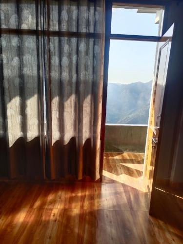 Habitación con ventana y vistas a la montaña. en Castle villa, en Shimla