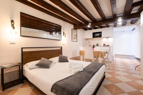 een slaapkamer met een groot bed en een keuken bij Fenix Colombina in Biennale - Your little house in Venetië