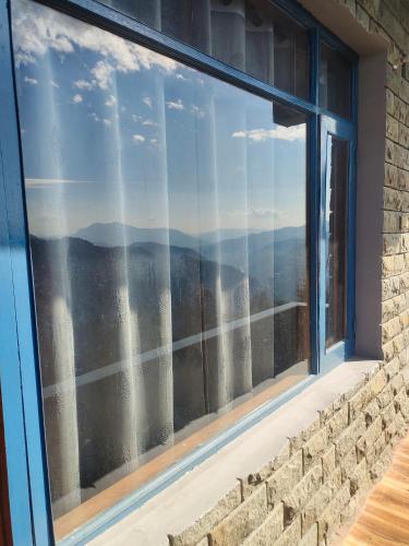 una ventana con vistas a las montañas en Castle villa en Shimla