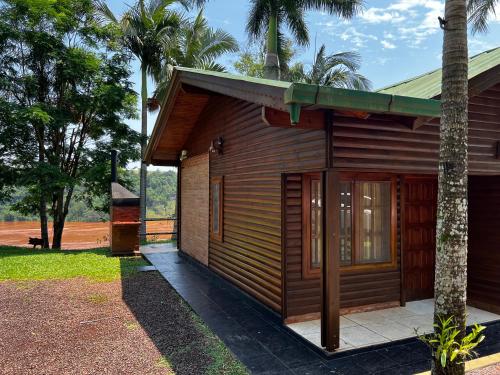 a small wooden building next to a palm tree at Costa del Sol Iguazú in Puerto Iguazú