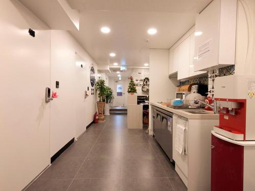 kuchnia z białymi szafkami i długim korytarzem w obiekcie One Minute Guesthouse w Seulu