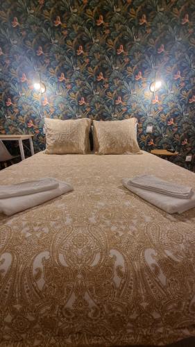 - une chambre avec un grand lit et du papier peint floral dans l'établissement 5e Ciel - [sans ascenseur - devant gare / centre-ville], à Tulle