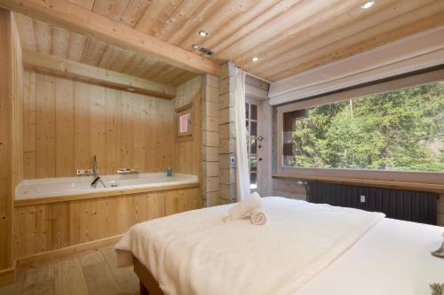 - une chambre avec un grand lit et une baignoire dans l'établissement Résidence Améthystes A2 ski in ski out - Happy Rentals, à Chamonix-Mont-Blanc