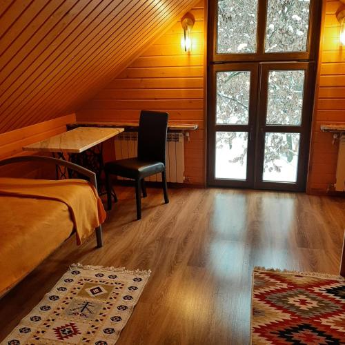 a bedroom with a bed and a desk and windows at Roztocze 3 kroki od sosny in Zamość