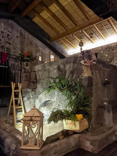 a wall with a painting on it with flowers and a lantern at PODERE DELL'ETNA SEGRETA - Essential Nature Hotel & Glamping in Biancavilla