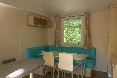 a dining room with a table and chairs and a window at Camping la Rouvière in Chame