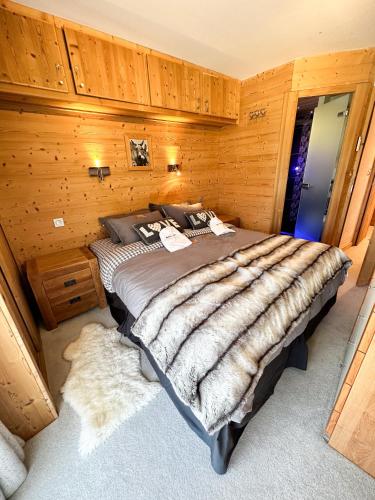 a bedroom with a large bed with wooden walls at Chalet Flocon - luxury ski chalet by Avoriaz Chale in Avoriaz