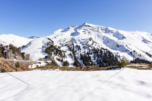 a mountain covered in snow with trees in the foreground at Chalet Flocon - luxury ski chalet by Avoriaz Chale in Avoriaz