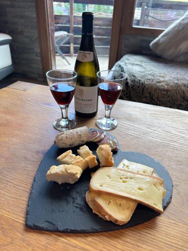 a plate of cheese and wine on a table at Chalet Flocon - luxury ski chalet by Avoriaz Chale in Avoriaz