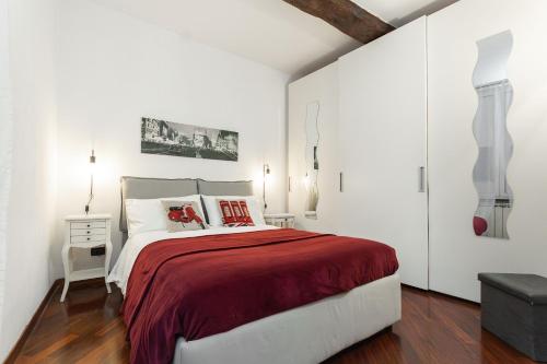 um quarto branco com uma cama grande com cobertor vermelho em CENTRO CITTÀ - ACQUARIO di Genova em Gênova