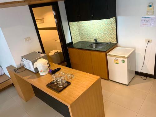 a kitchen with a sink and a counter with glasses on it at Tanawit Hotel Hua Hin in Hua Hin