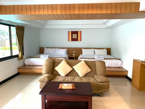 un soggiorno con divano e letto di Tanawit HuaHin Hotel a Hua Hin