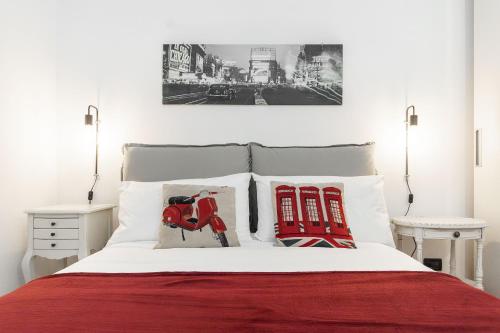 um quarto com uma cama com duas almofadas vermelhas e brancas em CENTRO CITTÀ - ACQUARIO di Genova em Gênova