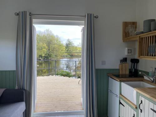 a kitchen with a door leading to a deck at The Lily Pod in New Abbey