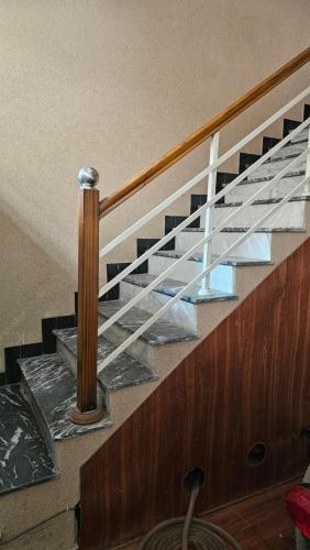 a metal staircase in a home with a wooden railing at Hotel Golden Inn in Karachi