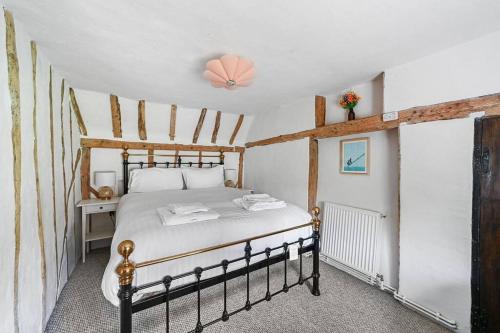 a bedroom with a large bed in a room at Micawber Cottage, Rattlesden in Rattlesden