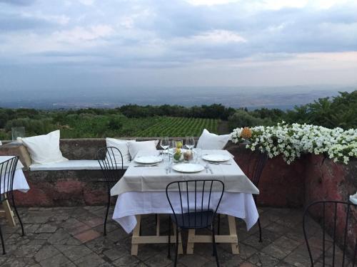 a table with a white table cloth on a patio at PODERE DELL'ETNA SEGRETA - Essential Nature Hotel in Biancavilla