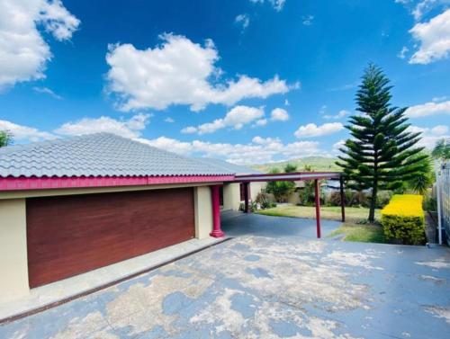 uma casa com garagem com telhado vermelho em Sunset Vista em Mataffin