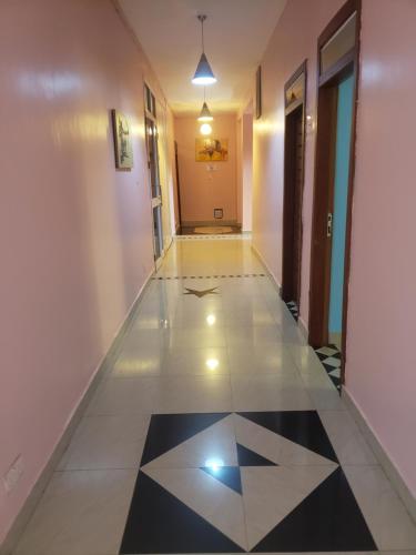 a hallway with a black and white tile floor at Dreamers Lodge in Prampram
