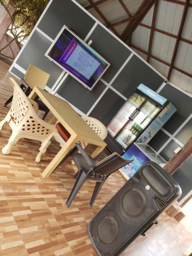a desk with a laptop computer and a table with a speaker at Dreamers Lodge in Prampram