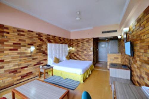 een slaapkamer met een bed en een bakstenen muur bij Hotel Clarks Grand , Gorakhpur in Gorakhpur