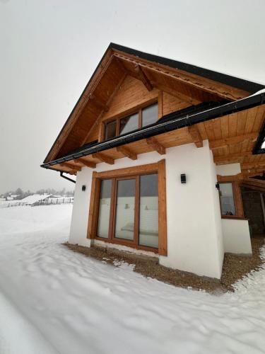 ein Haus im Schnee im Schnee in der Unterkunft Domek IGNAC in Ostrowsko