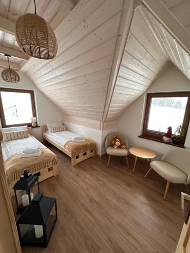 Habitación con 2 camas y mesa. en Domek IGNAC, en Ostrowsko