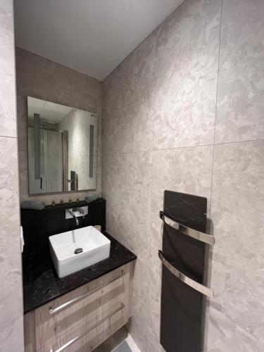 une salle de bain avec un lavabo et un miroir dans l'établissement Appartement à Saint-Paul en plein cœur du Marais 4 pers, à Paris