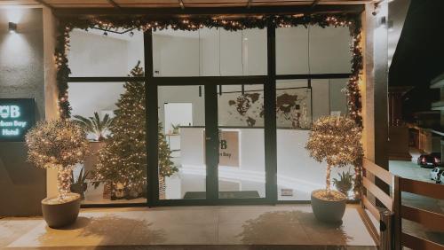 uma frente de loja com árvores de Natal e luzes de Natal em UrbanBay Hotel & Spa em Cavala