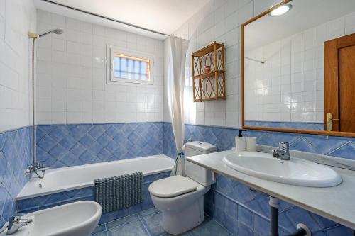bagno piastrellato blu con servizi igienici e lavandino di Casa Mirador Alquería a Granada