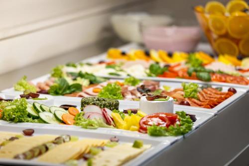 a row of trays filled with different types of food at Amedia Express Bielefeld, Trademark Collection by Wyndham in Werther