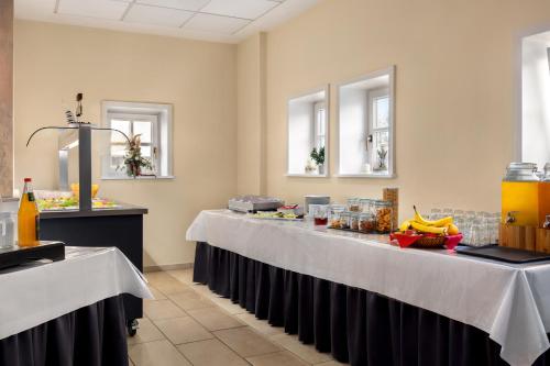 a buffet line in a restaurant with two tables at Amedia Express Bielefeld, Trademark Collection by Wyndham in Werther