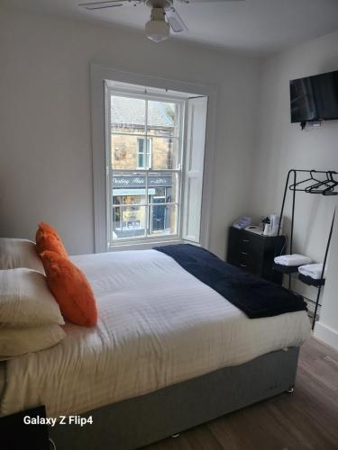 a bedroom with a bed with a large window at The Dock Hotel in Amble
