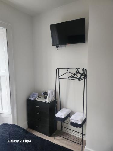 1 dormitorio con TV en la esquina de una pared en The Dock Hotel en Amble