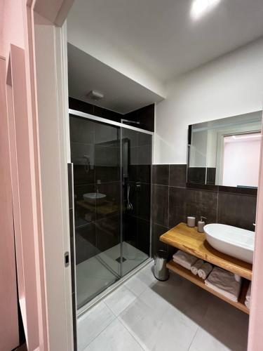 uma casa de banho com uma cabina de duche em vidro e um lavatório. em Joyfül Accomodation em Finale Ligure