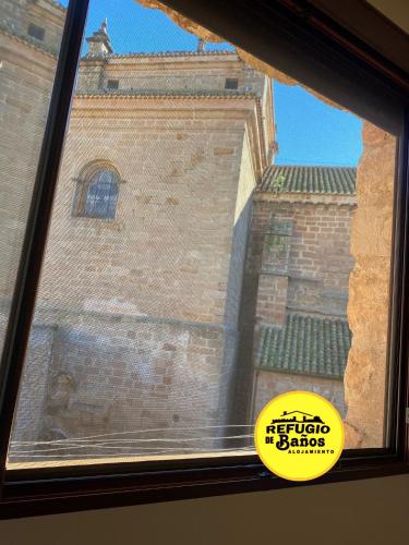 a view of a building from a window at Refugio de Baños in Baños de la Encina