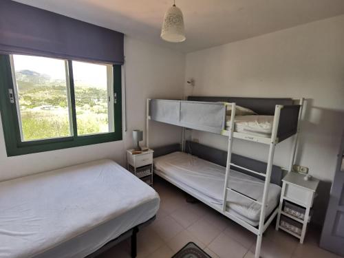 a bedroom with two bunk beds and a window at Apartamento Llançà, 2 dormitorios, 6 personas - ES-89-111 in Llança