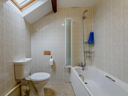 a bathroom with a toilet and a bath tub at 3 Bed in Builth Wells 52463 