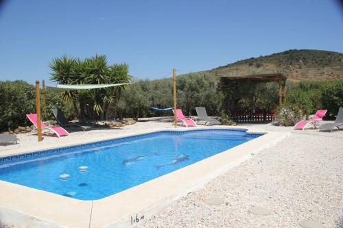 a swimming pool with pink chairs at Stunning Villa Felipe, with private pool & hot tub in Almogía
