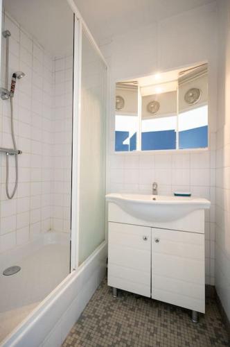 une salle de bain blanche avec un lavabo et une douche dans l'établissement Super studio tout équipé - III, à Paris