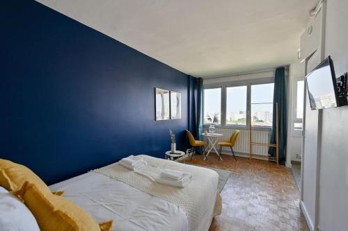 - une chambre bleue avec un lit et une table avec des chaises dans l'établissement Super studio tout équipé - III, à Paris