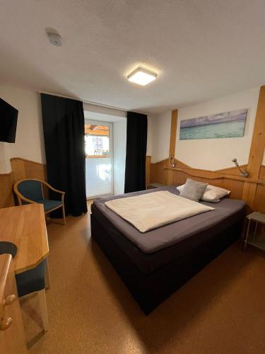 a bedroom with a bed and a table and a desk at Pension Maintal Eltmann in Eltmann