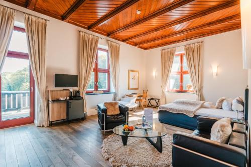 ein Wohnzimmer mit einem Bett und einem Sofa in der Unterkunft Schloss Ranzow Privathotel - Wellness, Golf, Kulinarik, Events in Lohme
