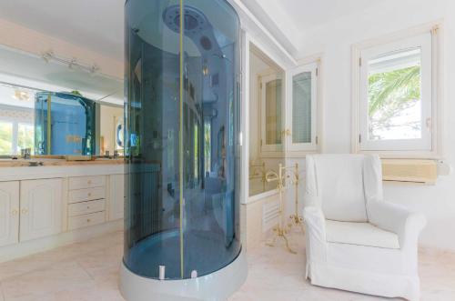 セス・サリネスにあるCasa Bonita (Ses Salines)の白い椅子付きの客室内の大きなガラス張りのシャワー