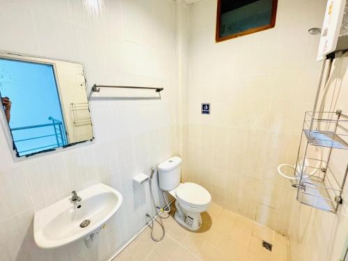 Baño blanco con aseo y lavamanos en Journey Hostel Haad Rin, en Haad Rin