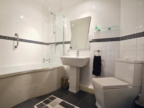 a bathroom with a sink and a tub and a toilet at 2 Bed in Seahouses CN198 in Seahouses